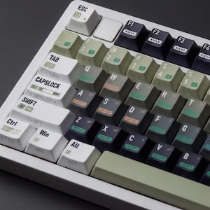 May include: A white mechanical keyboard with a variety of keycap colours, including white, black, and shades of green. The keyboard has a compact layout and features the word "ELEMENTS" on the spacebar.