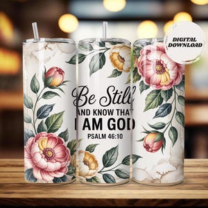 Puede incluir: Tres vasos de acero inoxidable blancos con diseños florales y el texto "Be Still and Know That I AM GOD" del Salmo 46:10. Los vasos presentan flores rosas y amarillas con hojas verdes.