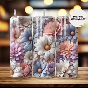 May include: Three floral-themed tumblers with lids and straws. The tumblers are covered in a pattern of white, pink, purple, and blue flowers. The tumblers are cylindrical and sit on a wooden surface. The image includes a digital download sticker.
