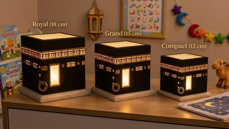 Three sizes of the black Kaaba night light are displayed on a shelf labeled Royal, Grand, and Compact.
