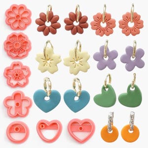 May include: A collection of colorful earrings in various shapes, including flowers, hearts, and circles. The earrings are in shades of pink, brown, yellow, blue, green, purple, and orange. Some earrings have gold-colored hoops.