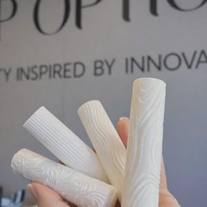 May include: A handmade wooden sign displaying the word "Welcome" in a whimsical font. The sign is painted white with a distressed finish, and features a floral design in pinks and greens. Suitable for indoor or outdoor use.