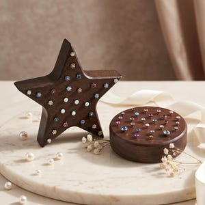 May include: A dark brown wooden star-shaped display stand and a matching circular wooden base, both featuring numerous small, colorful gemstone stud earrings inserted into the wood surfaces to showcase the jewelry pieces in an organized manner.