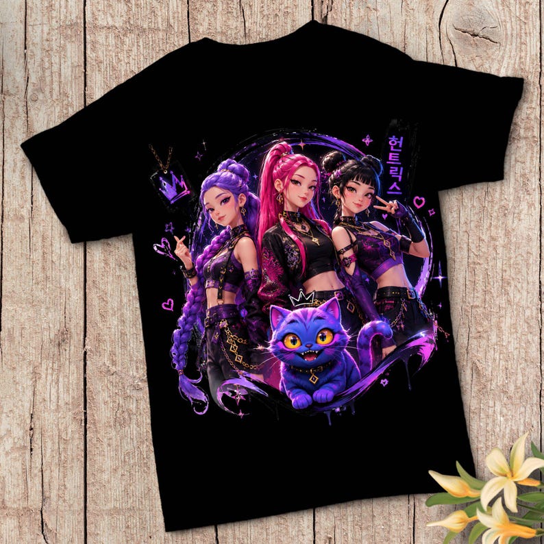 Pode incluir: Uma t-shirt preta de manga curta com uma estampa gr&aacute;fica de tr&ecirc;s personagens estilo anime com cabelo roxo e rosa, acompanhados por um gato roxo. O design inclui texto em coreano, s&iacute;mbolos de cora&ccedil;&atilde;o e um &iacute;cone de coroa.