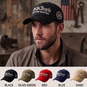 Puede incluir: Gorra de béisbol negra con el texto "We the People HAVE HAD ENOUGH" en escritura blanca. La gorra también presenta un emblema "1776". Opciones de color adicionales incluyen verde oliva, rojo, azul y arena.