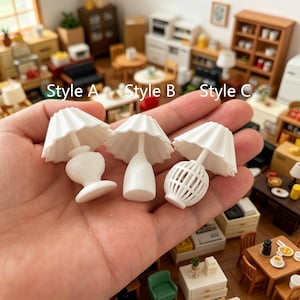 May include: Three miniature white table lamps labeled Style A, Style B, and Style C. Style A has a rounded base, Style B features a smooth tapered base, and Style C has a cage-like base. Each lamp includes a pleated, flared lampshade.