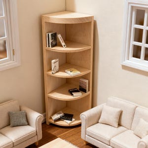 Può includere: Una libreria angolare in miniatura in legno con ripiani curvi, contenente diversi piccoli libri. La libreria è ambientata in un ambiente di casa delle bambole, insieme a piccoli divani, un tavolino e una finestra.