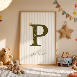 Peut inclure: Une affiche encadrée avec une grande lettre "P" vert olive ornée d'une fleur et le nom "Pablo" en écriture cursive. Le fond est à rayures beiges et blanches. La pièce est décorée d'ours en peluche et de jouets.