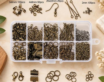 May include: A clear plastic storage box containing various bronze-toned metal jewelry findings, including lobster clasps, jump rings, crimp ends, eye pins, and earring hooks. Text labels indicate sizes and quantities, such as 3x6mm 100pcs and 25mm 50pcs.