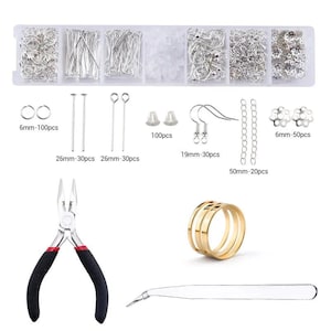 May include: A jewelry making kit featuring a clear plastic organizer box filled with silver-toned jump rings, head pins, eye pins, earring hooks, chains, and flower beads. Includes a pair of black-handled pliers, a gold-toned ring, and tweezers.