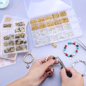 May include: Two clear plastic storage containers filled with assorted metal jewelry findings including gold and silver earring hooks, jump rings, and eye pins. A pair of metal pliers is used to assemble a white pearl bead hoop earring with a starfish charm.