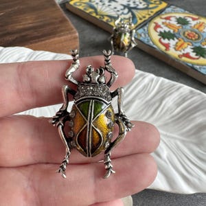 Op de afbeelding: Een witte keramische mok met een zwart handvat en de tekst "But First, Coffee" in een handschriftstijl. De mok staat op een wit oppervlak. De mok is ongeveer 10 cm hoog.