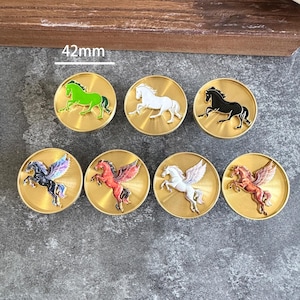 Può includere: Sette sigilli in ceralacca circolari in metallo dorato, ciascuno con un diametro di 42 mm. La fila superiore presenta cavalli in verde, bianco e nero. La fila inferiore mostra quattro figure di pegaso alato con finiture nera, rossa, bianca e rame.