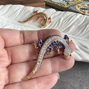 May include: A white ceramic mug with a black handle and the text "But First, Coffee" in a bold, black font. The mug is sitting on a wooden surface. The mug is approximately 4 inches tall.