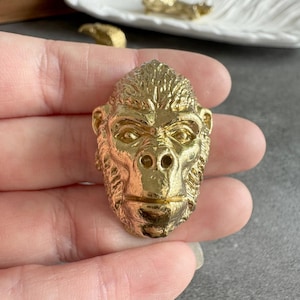 Könnte beinhalten: Ein Set aus drei Keramikbechern mit gesprenkelter, matter Oberfläche. Die Becher sind in Creme-, Hellgrau- und Dunkelgrautönen gehalten. Jeder Becher hat ein schlichtes, minimalistisches Design und einen abgerundeten Henkel.