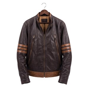 Può includere: Una giacca in pelle marrone scuro con colletto alla coreana, chiusura centrale con zip e due tasche verticali con zip sul petto. Le maniche sono caratterizzate da tre strisce orizzontali in pelle color cuoio e l'orlo è rifinito con una fascia.