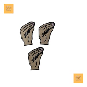 May include: Three embroidered patches featuring a hand gesture, with a tan palm and black details. The patches are arranged on a white background. The patches are likely for clothing or accessories.