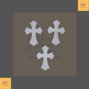 May include: Three white cross-shaped cutouts with a textured surface arranged in a triangular formation. Each cross features a distinct flared design at the ends of the arms and a central vertical and horizontal intersection point.