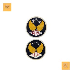May include: Two circular patches featuring a black backdrop, yellow wing-like designs, and white stars. The patches display the letters "R" and "L" in red. Each patch is encircled by a white border.