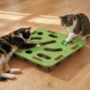 Può includere: Un gioco puzzle verde per gatti con più fori e tunnel, progettato per stimolare gli istinti di caccia dei gatti. Due gatti, uno calico e uno tabby, interagiscono con il gioco su un pavimento in legno.