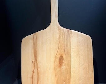 May include: A wooden pizza peel with a long handle. The peel is made of light wood with a natural grain pattern.