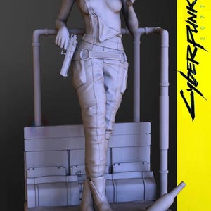 May include: A grey 3D-printed figurine of a woman from Cyberpunk 2077, holding a pistol and a cigarette. She wears a jumpsuit and boots. The base features the game's logo and a bottle. The background is grey with a yellow panel with the game's title.