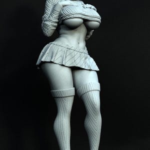 Può includere: Una statuetta in resina grigia monocromatica di un personaggio con caschetto e occhiali, che indossa un maglione a trecce, una gonna a pieghe e calze autoreggenti. La figura poggia su una base circolare, mostrando texture del tessuto dettagliate.