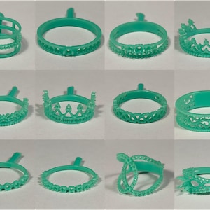 May include: A collection of turquoise-colored ring molds in various designs. The rings feature intricate patterns, including crowns, geometric shapes, and openwork details. Each ring is attached to a sprue for casting.