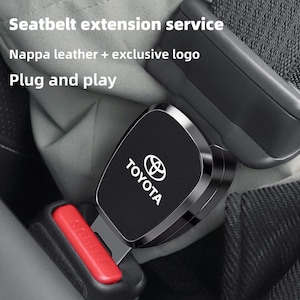 May include: A black Nappa leather seatbelt extension with a metallic Toyota logo and silver trim. The device is inserted into a red release button buckle. Text on the image reads: Seatbelt extension service, Nappa leather + exclusive logo, Plug and play.