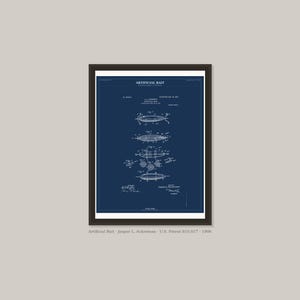 May include: A framed print featuring a vintage blueprint of an artificial bait design. The blueprint is in white against a dark blue background. The text "Artificial Bait" is at the top, with detailed diagrams below.