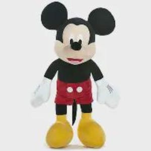 May include: A plush Mickey Mouse toy, with a black body, red shorts, and yellow shoes. The character has large black ears, a tan face, and white gloves. The toy is standing upright against a white background.