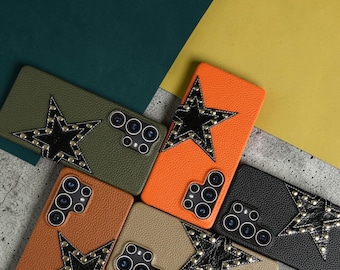 Op de afbeelding: Een verzameling leren telefoonhoesjes in verschillende kleuren, waaronder olijfgroen, oranje, beige en zwart. Elke hoes heeft een zwart sterontwerp versierd met zilveren studs. De hoesjes zijn ontworpen voor specifieke telefoonmodellen.