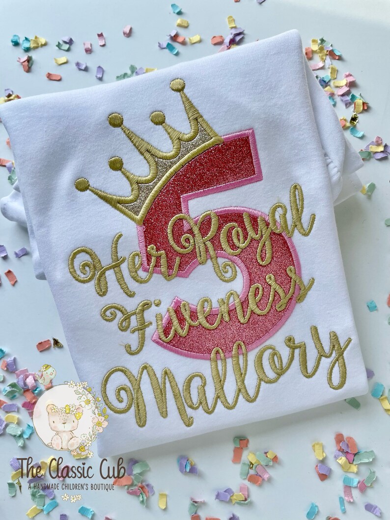 Peut inclure: Chemise blanche avec broderie dor&eacute;e d'une couronne, du chiffre 5, des mots "Her Royal Highness" et du nom "Mallory".
