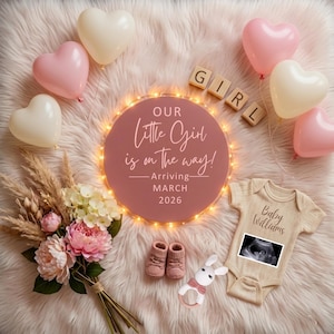 May include: A baby announcement with a pink and white theme. The image includes heart-shaped balloons, a floral bouquet, baby booties, a rattle, and a onesie with an ultrasound image. The announcement reads "Our Little Girl is on the way! Arriving March 2026."
