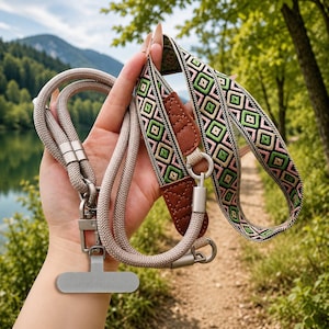 May include: A beige rope lanyard featuring a patterned fabric strap with a geometric diamond design in pink, green, and black. The strap includes brown faux leather accents, silver-toned metal swivel clasps, and a flat silver-toned metal attachment.