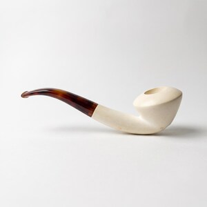 Pipa de tabaco de espuma de mar tallada a mano con boquilla curva de carey y acabado pulido liso.