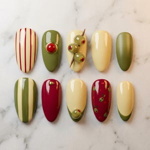 May include: A collection of ten almond-shaped nail designs. The designs feature various colors and patterns, including olive green, cream, and burgundy. Some nails have vertical stripes, while others feature olive and red accents.