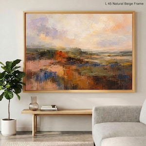 May include: A large rectangular landscape painting in a natural beige frame titled L 45 Natural Beige Frame. The artwork features an abstract impressionist scene with layered brushstrokes in shades of orange, blue, green, and cream, depicting a textured horizon line under a soft, hazy sky.