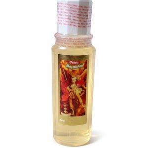 May include: A clear glass bottle with a white cap and a gold label featuring an illustration of a saint. The bottle contains a light yellow liquid. The label reads "Cybele Holy Michael".