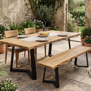 May include: A wooden dining table with a live edge and black metal legs, with matching chairs and a bench. The table is set with plates and a bowl of fruit, creating an inviting outdoor dining scene.