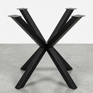 May include: Black metal table legs with a modern, geometric design. The legs are angled and cross in the center, with flat mounting plates at the top. The legs are made of a sturdy metal and are suitable for a variety of table tops.