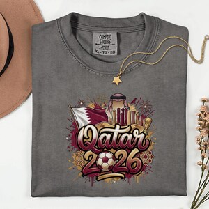 Camiseta de fútbol de Qatar 2026 Comfort Colors®, camiseta gráfica estilo fútbol para aficionados al deporte, regalo para seguidores, camiseta unisex del país del torneo mundial. imagen 1