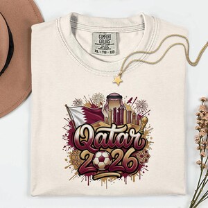 Camiseta de fútbol de Qatar 2026 Comfort Colors®, camiseta gráfica estilo fútbol para aficionados al deporte, regalo para seguidores, camiseta unisex del país del torneo mundial. imagen 2