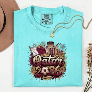 Camiseta de fútbol de Qatar 2026 Comfort Colors®, camiseta gráfica estilo fútbol para aficionados al deporte, regalo para seguidores, camiseta unisex del país del torneo mundial. imagen 6