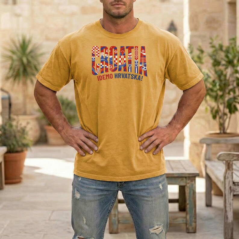 May include: Mustard yellow t-shirt with the word "CROATIA" in a multi-colored design, and the text "IDEMO HRVATSKA!". The shirt is a short-sleeved crew neck style.