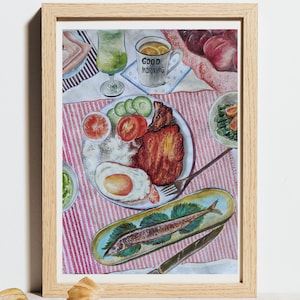 May include: Watercolor painting of a breakfast scene with a plate of food, a cup with the words "GOOD MORNING", and a glass of green liquid. The painting is framed in a light wood frame.