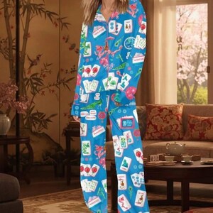 K&ouml;nnte beinhalten: Ein blaues Pyjama-Set mit einem Aufdruck von Spielkarten und spielbezogenen Grafiken. Das lang&auml;rmlige Oberteil und die Hose sind aus einem weichen Material gefertigt. Das Pyjama-Set ist eine bequeme Schlafbekleidung.