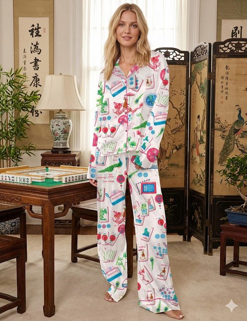 K&ouml;nnte beinhalten: Wei&szlig;es Satin-Pyjama-Set mit farbenfrohem Mahjong-Fliesen-Print. Das lang&auml;rmlige Oberteil und die Hose haben ein Hemd mit Kn&ouml;pfen und eine lockere Passform. Der Druck enth&auml;lt Illustrationen von Drachen, Pfauen und Laternen.