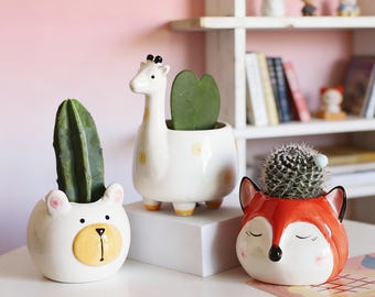 Vasos de cerâmica esmaltada à mão em formato de animais: raposa, girafa e urso.