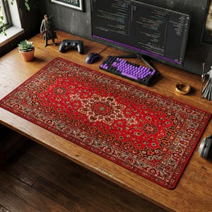 Puede incluir: Alfombrilla de escritorio rectangular con un diseño de alfombra persa roja y beige. La alfombrilla está sobre un escritorio de madera, con un monitor de ordenador, teclado y ratón. La alfombrilla mide aproximadamente 91 cm de largo y 41 cm de ancho.